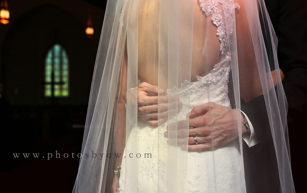 grooms_hands_on_brides_back_veil